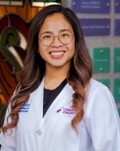 woman with ling curled hair and glasses on smiling