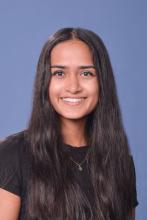 woman in a black top with dark, long hair smiling