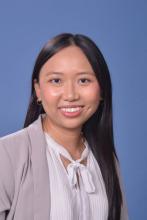 woman in buisiness attire with long dark hair smiling