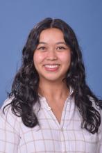 woman with dark curly hair smiling