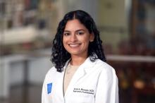 woman with dark, curly hair smiling