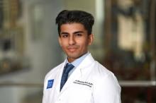 man with short dark hair smiling lightly