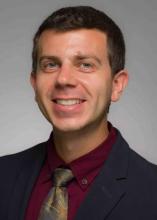 man with short brown hair smiling