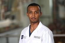 man with short, dark hair smiling lightly