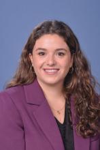 woman with long, curly brown hair smiling