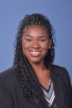 woman with curly hair in a half-up hairstyle smiling