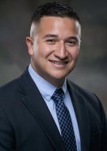 mn with short dark hair smiling