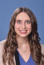 woman with brown, curled hair smiling