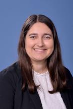 woman in a blazer with dark brown hair smiling