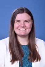 woman in business attire with dark blonde hair smiling