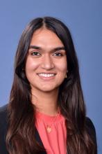 woman in a pink top with dark hair smiling