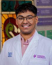 man with short dark hair and glasses on smiling