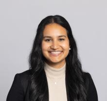 woman with a beige turtle neck shirt on smiling