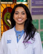 woman with long, dark curled hair smiling