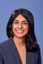 woman with hoop earrings and shoulder length hair smiling