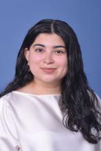 woman in a hite blouse with dark hair smiling
