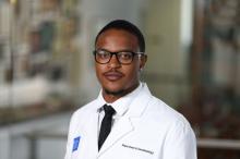 man with a buzz cut and glasses on smiling