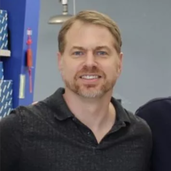 man smiling in front of grey background