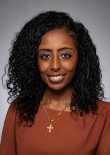 woman with curly, shoulder length hair smiling