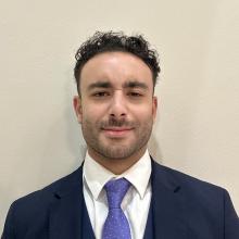 man with short curly hair smiling