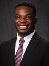 man in a suit with a red and blue tie on smiling
