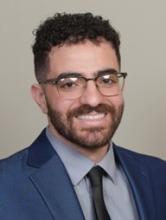 man with short curly hair and glasses on smiling