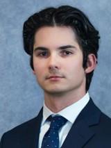 man in a suit and short dark hair smiling