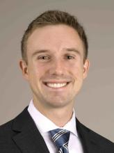 man in a suit with short blonde hair smiling