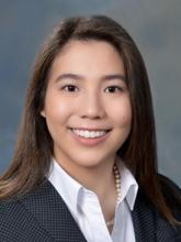 woman in business attire with long brown hair smiling