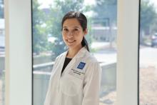 woman with her hair in a low ponytail smiling