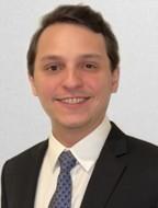 man with side-parted brown hair smiling