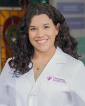 woman with brown, curly hair smiling
