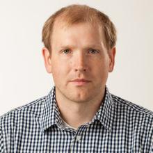 man smiling in front of grey background
