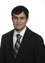 man smiling in front of grey background