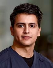 man with short dark hair smiling lightly