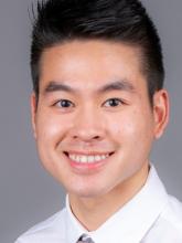 man with short black hair smiling