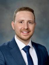 man in a blue suit and tie smiling