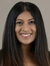 woman with straight dark hair in a middle part smiling