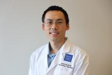 man with short dark hair and glasses on smiling