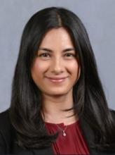woman in a red blouse with dark hair smiling
