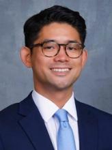 man in a suit with glasses on smiling