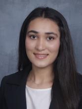 woman with dark hair in a blacck blazer smiling