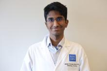 man with dark hair and glasses on smiling