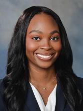 woman in a blazer with long dark hair smiling