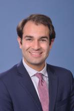 man in a suit with brown hair smiling