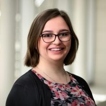 woman with short brown hair and glasses on smiling