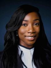 woman with dark, wavy hair smiling