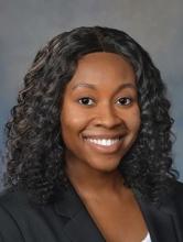 woman with dark, curly hair smiling