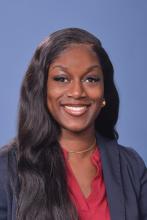 woman in a red top with long dark hair smiling