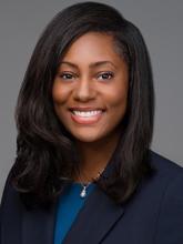 woman in a blazer and dark blue top with shoulder length hair smiling